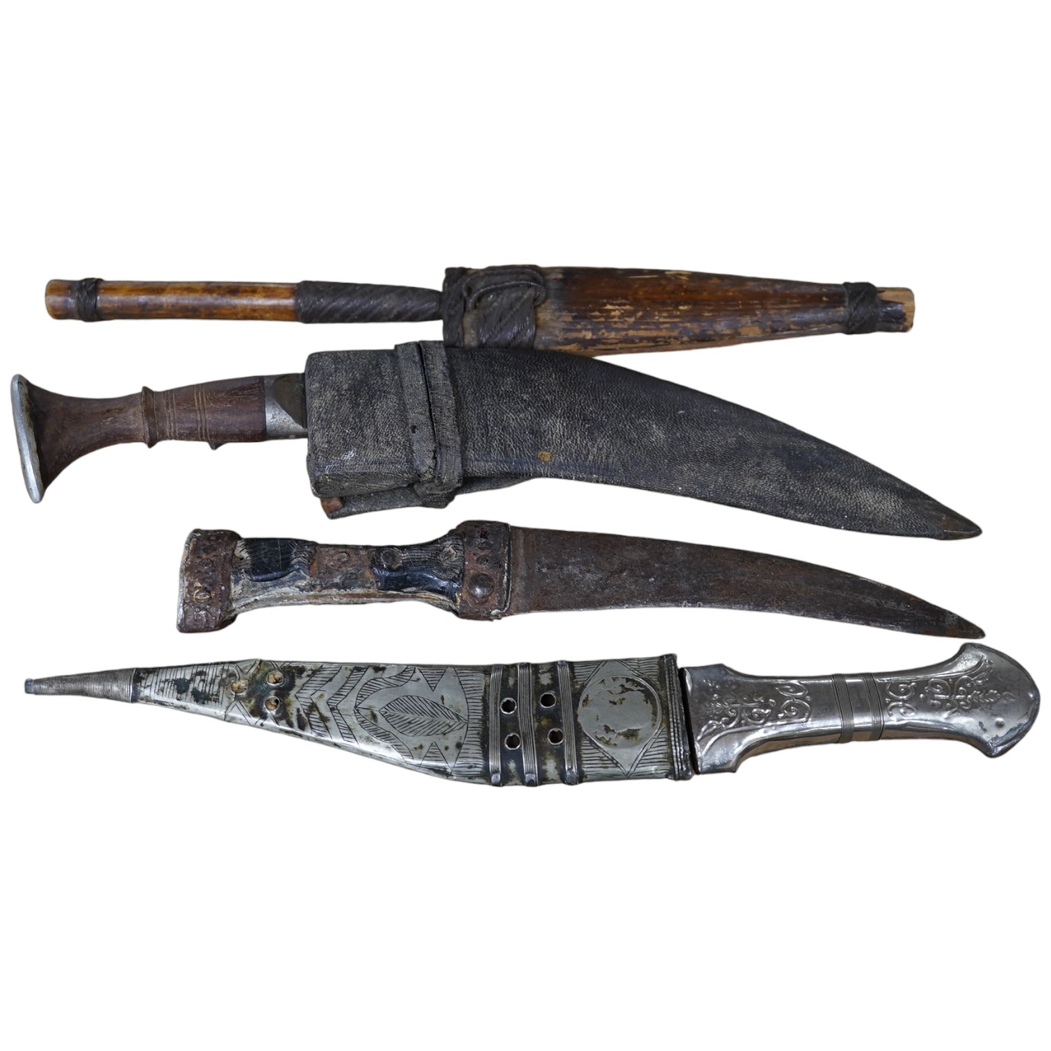 Three daggers, two with sheaths and a kukri knife, largest 33cm in length. Condition - poor